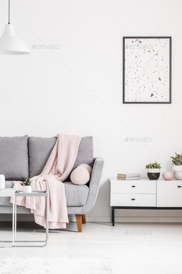 Modern poster on a white wall, grey sofa with blanket and cabine Stock